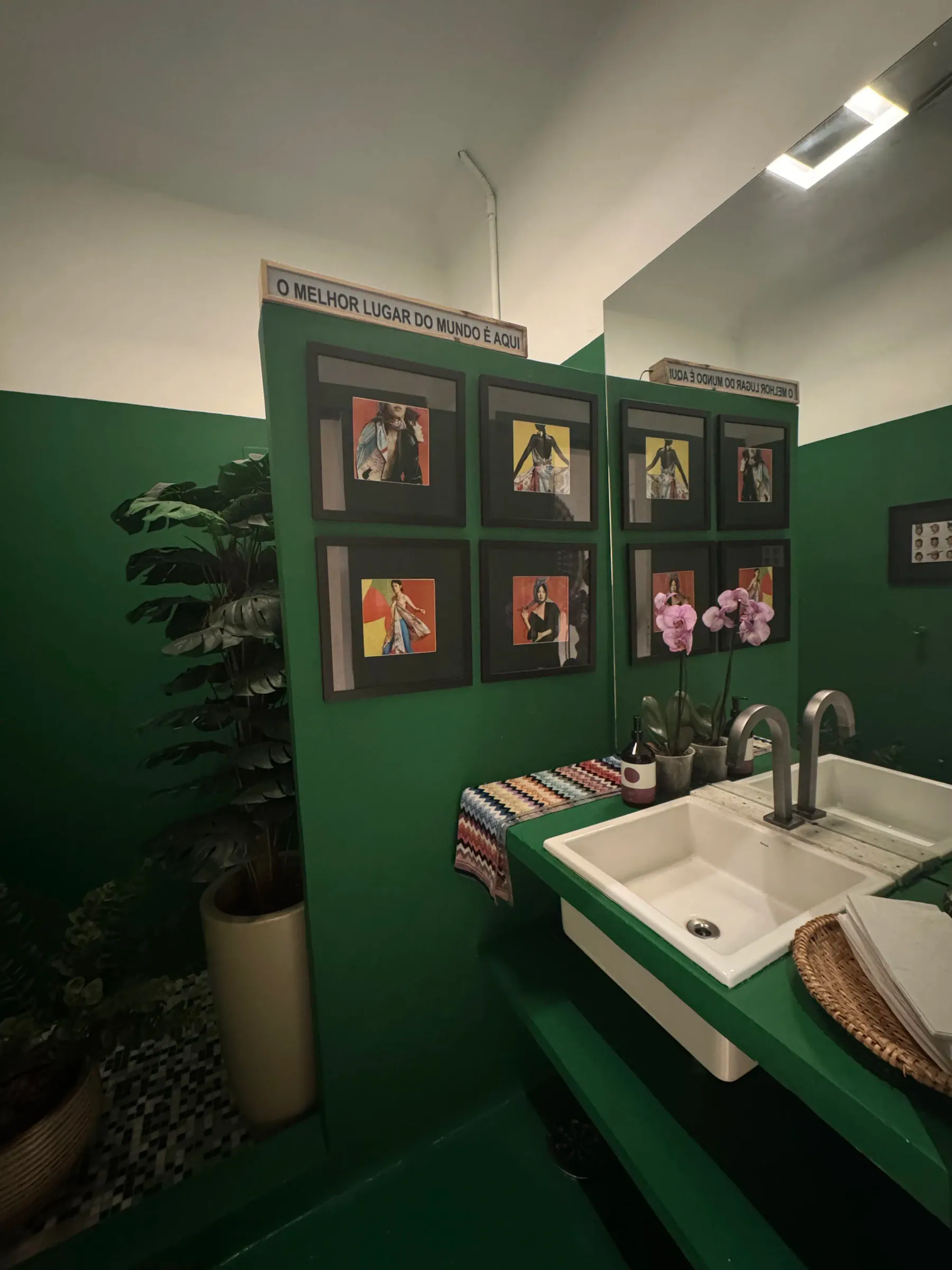 Lavabo decorado com quadros e orquídeas